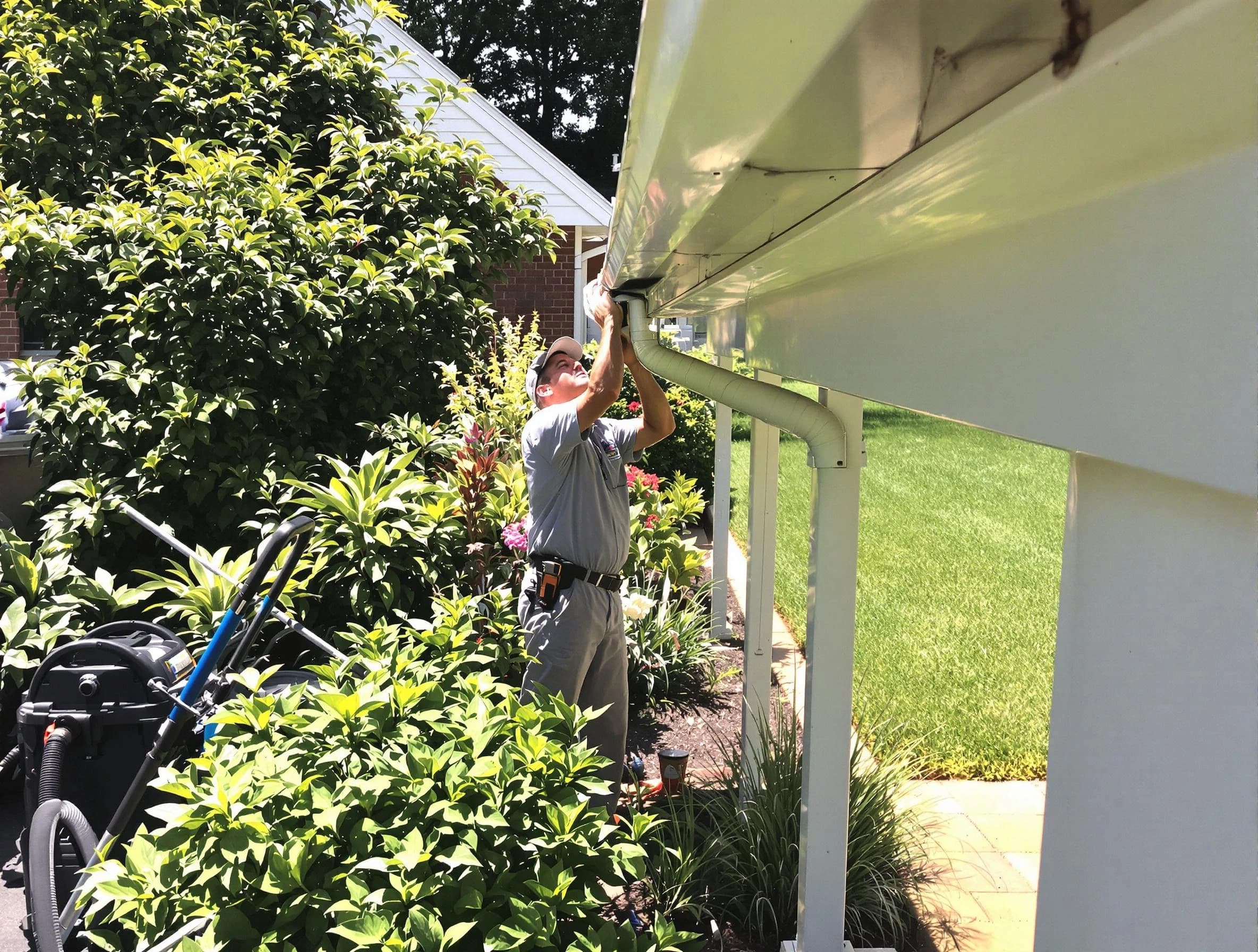 Technician flushing a blockage from a downspout in Cuyahoga Falls, OH